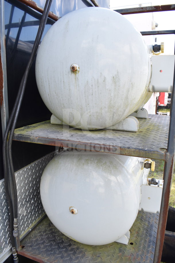 Two propane tanks mounted on a metal platform, part of a 2021 Cruising Kitchens food trailer. Slight signs of wear.