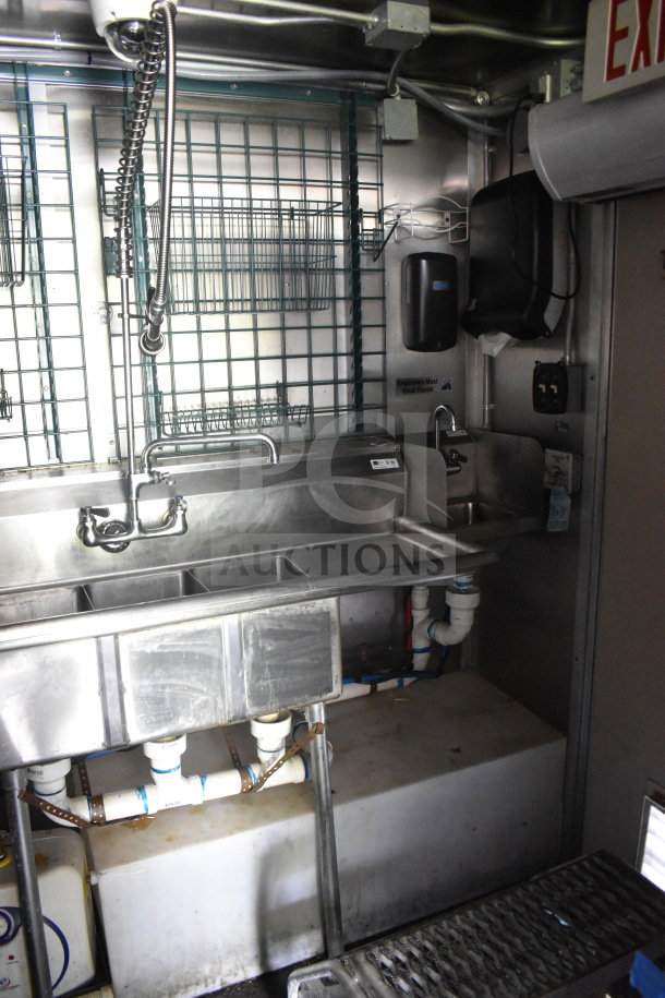 2020 Diamond Cargo 8.5'x24' food trailer interior, features a multi-compartment stainless steel sink setup, visible plumbing, and wall shelves.