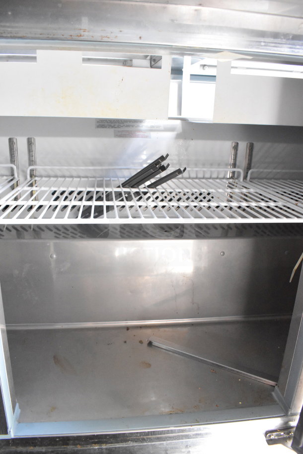 Interior view of the 2020 Diamond Cargo 8.5'x24' Food Trailer, featuring stainless steel shelving and slight wear.
