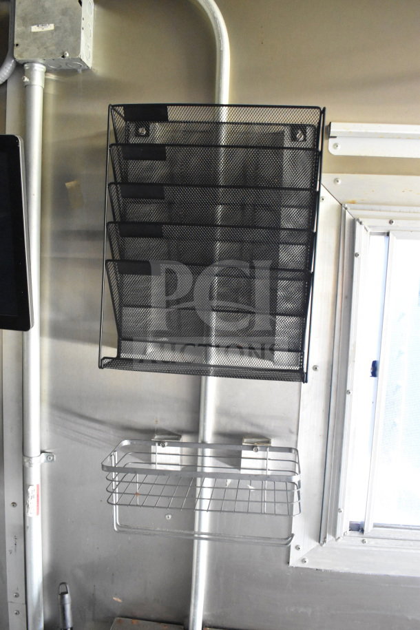 Interior of 2020 Diamond Cargo 8.5'x24' Food Trailer featuring mounted black wire racks and shelving, displaying storage solutions.