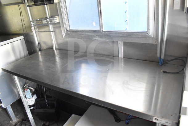 Interior view of 2020 Diamond Cargo 8.5'x24' food trailer, featuring a stainless steel countertop, visible wiring, and shelving.