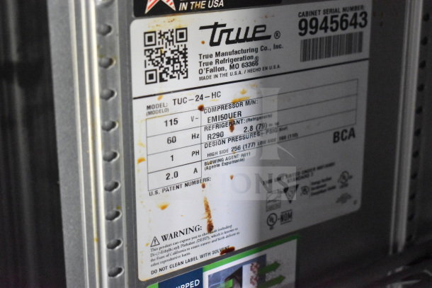 Label on equipment showing True Manufacturing details, model TUC-24-HC, refrigeration specs, and warning information.