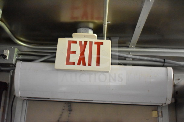 Interior view of a 2020 Diamond Cargo 8.5'x24' food trailer showing an "EXIT" sign and overhead metal piping.