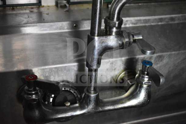 Close-up of a dual-handle kitchen faucet in the 2020 Diamond Cargo 8.5'x24' food trailer, showing metal construction and light wear.