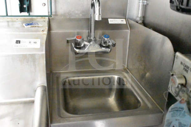 Stainless steel sink in Diamond Cargo 8.5'x24' food trailer, dual faucet, clean condition. NSF label visible on left.