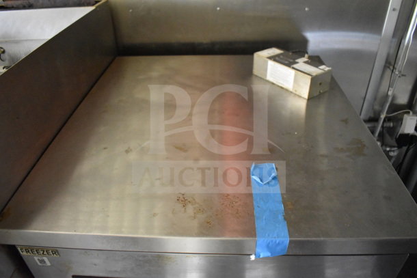 2020 Diamond Cargo 8.5'x24' food trailer interior, stainless steel work surface, minor wear, visible tape and freezer label.