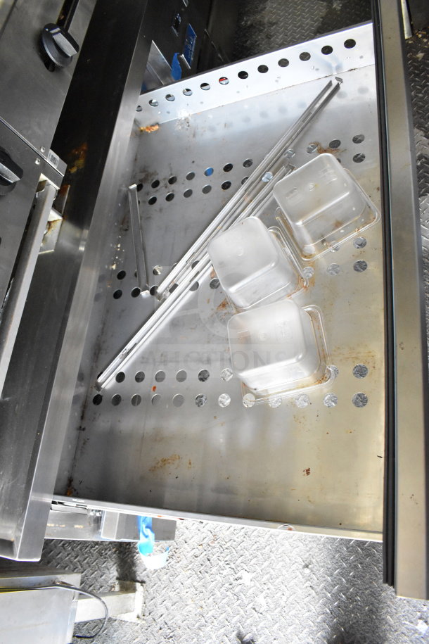 2020 Diamond Cargo 8.5'x24' food trailer interior. Shows storage rack with perforated metal and plastic containers.