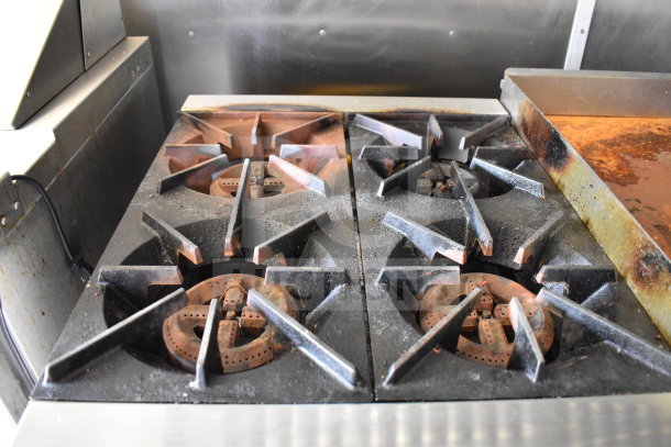 Close-up of four-burner stovetop inside the 2020 Diamond Cargo 8.5'x24' food trailer, showing moderate use and wear.