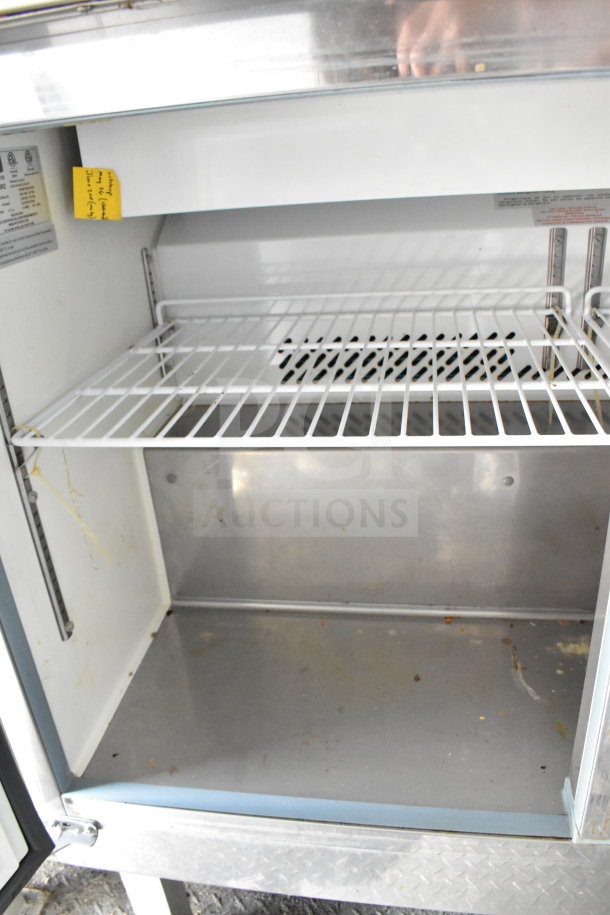 2020 Diamond Cargo 8.5'x24' food trailer interior view, showing metal shelving. Visible labels with usage instructions. Good condition.