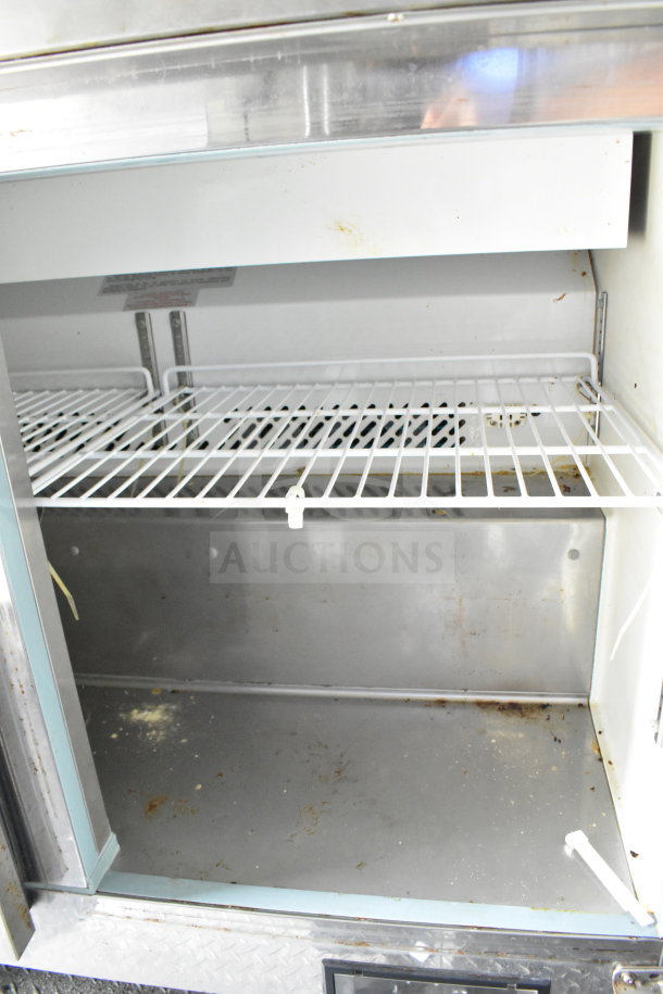 Interior view of a 2020 Diamond Cargo 8.5'x24' food trailer showing metal shelves. Some wear and dirt visible on surfaces.