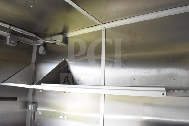 2020 Diamond Cargo 8.5'x24' food trailer interior, visible stainless steel shelves and walls, showing wiring and outlet.