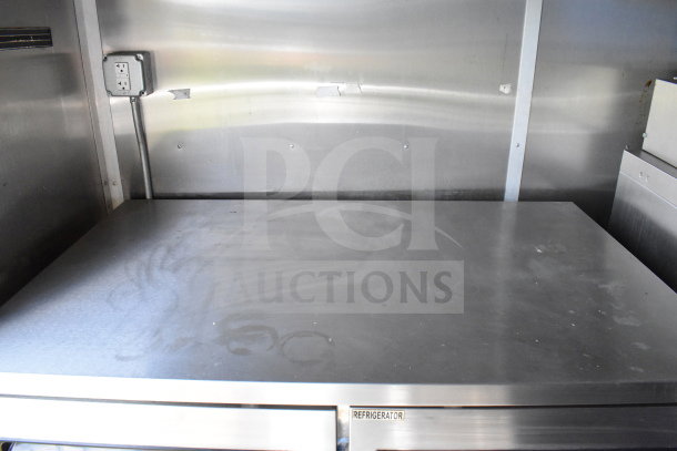 2020 Diamond Cargo 8.5'x24' food trailer interior, stainless steel surfaces, visible refrigerator label, good condition.