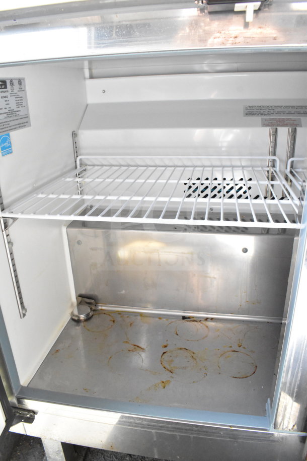 Interior of a 2020 Diamond Cargo food trailer showing a used stainless steel compartment with wire shelf and visible residue.