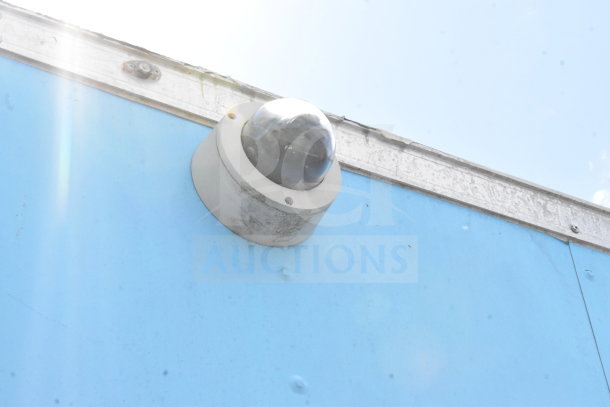 Security camera mounted on the exterior of a blue 2020 Diamond Cargo 8.5'x24' food trailer.