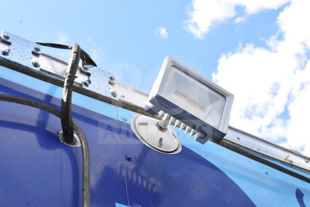 2020 Diamond Cargo food trailer exterior light detail, showcasing wiring and metal fixtures under a blue sky.