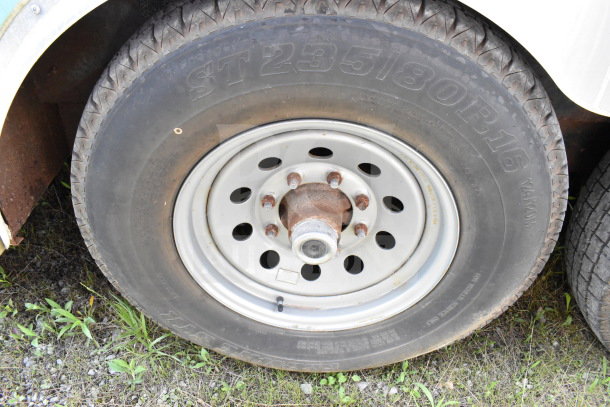 Close-up of a tire on a 2020 Diamond Cargo 8.5'x24' food trailer. Tire size: ST235/80R16. Visible wear on wheel rim.