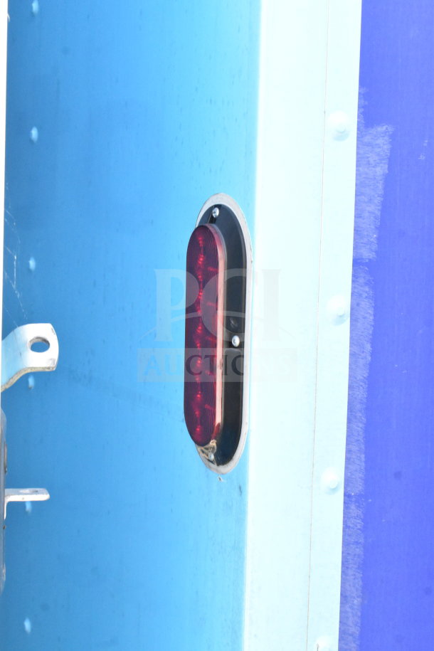 Red side marker light on blue exterior of 2020 Diamond Cargo food trailer.
