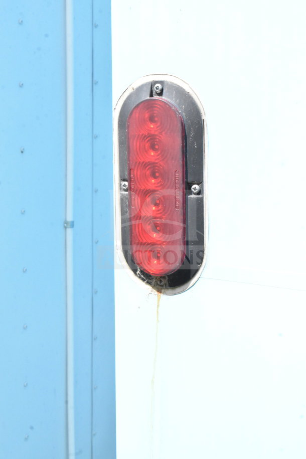 Close-up of a red taillight on a 2020 Diamond Cargo 8.5'x24' food trailer, showing minor rust below.
