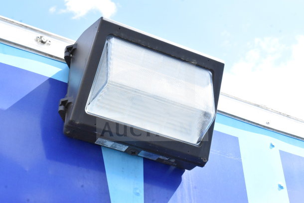 Outdoor light fixture on blue exterior wall of 2020 Diamond Cargo food trailer, providing illumination.