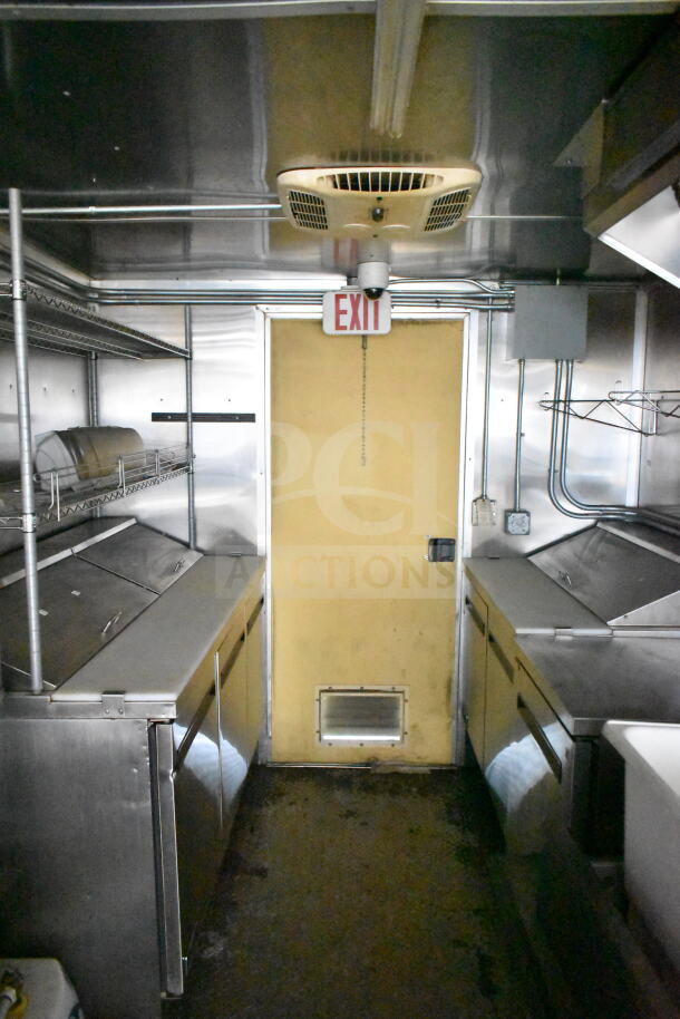 2021 Diamond Cargo 8.5'x24' food trailer interior, featuring stainless steel countertops, shelving, and visible grease hood system.