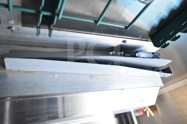 Interior view of 2021 Diamond Cargo food trailer, showing metallic surfaces and storage area, part of grease hood visible.