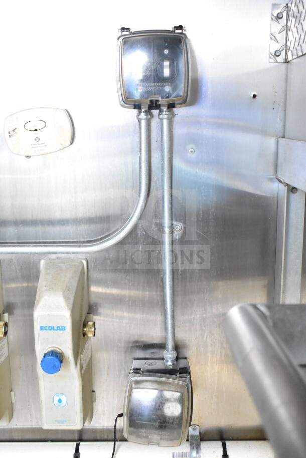 Interior view of 2021 Diamond Cargo 8.5'x24' food trailer. Includes electric components, Ecolab system, and wall fixtures.