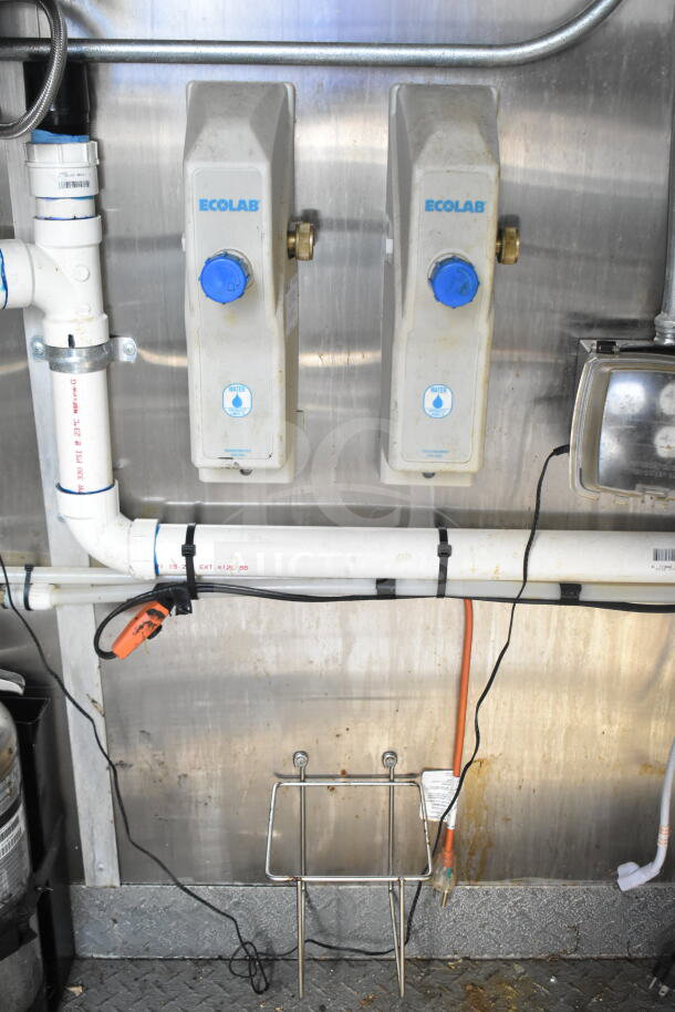 2021 Diamond Cargo food trailer interior showing Ecolab water dispensers, piping, and outlet. Features grease hood and refrigeration.