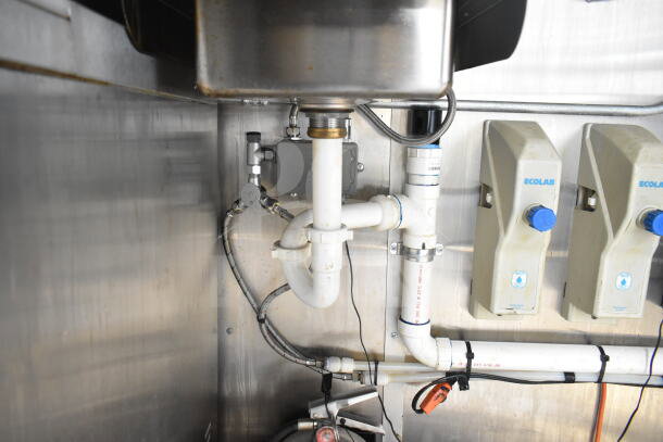 Interior of 2021 Diamond Cargo food trailer showing plumbing under a stainless steel sink, with visible Ecolab dispensers.