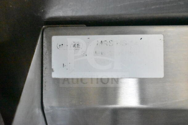 Close-up of a label on a stainless steel surface, details blurred and unreadable. Part of a 2021 Diamond Cargo food trailer.