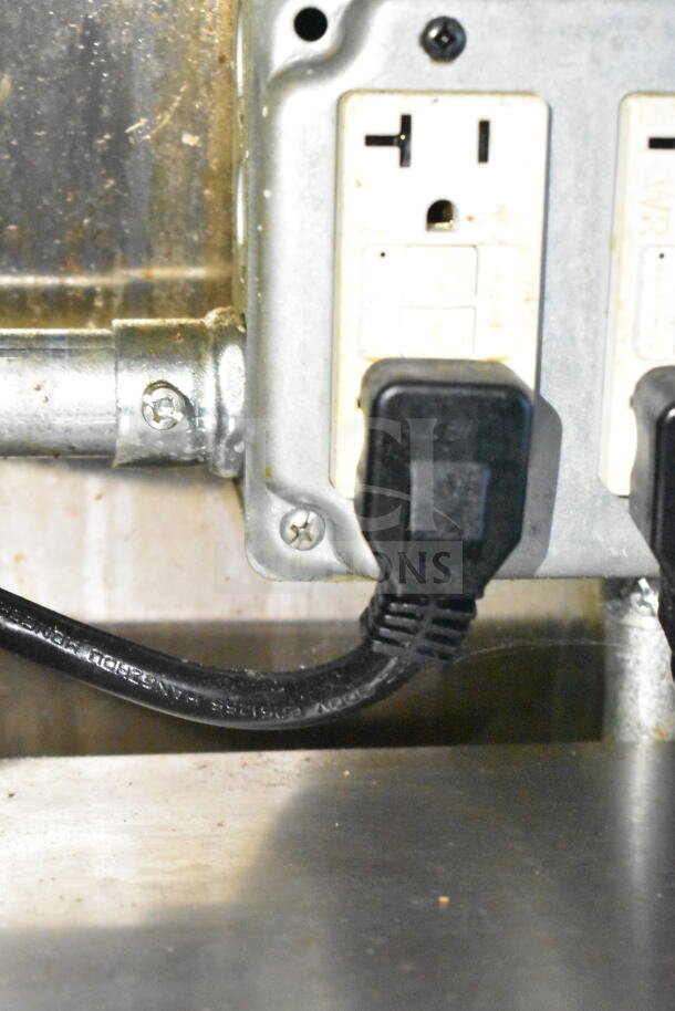 Electrical outlet and plugs inside 2021 Diamond Cargo 8.5'x24' food trailer showing wired connections and metal frame.