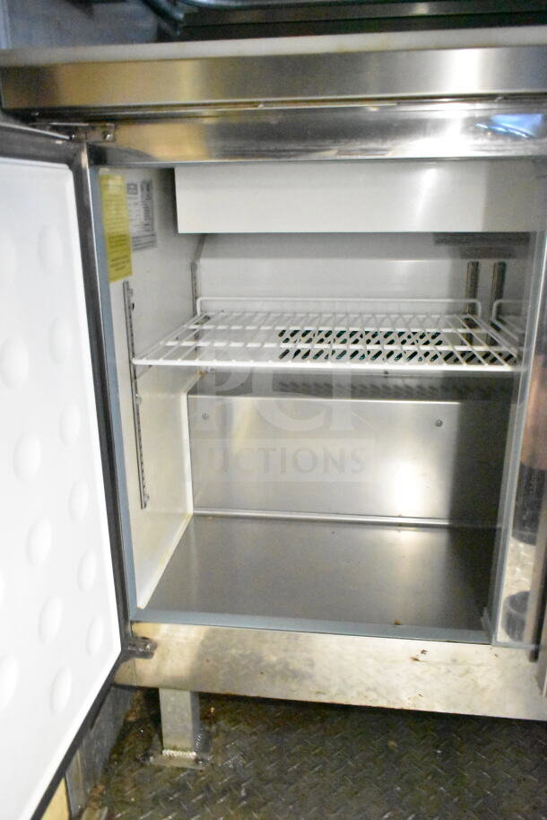 Interior view of a 2021 Diamond Cargo food trailer's refrigeration unit, showing clean metal surfaces and shelving.