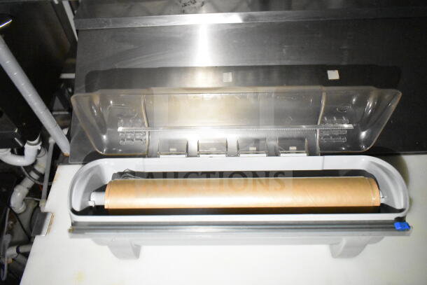 2021 Diamond Cargo 8.5'x24' food trailer interior, featuring a plastic wrap dispenser with a clear lid and stainless steel surface.