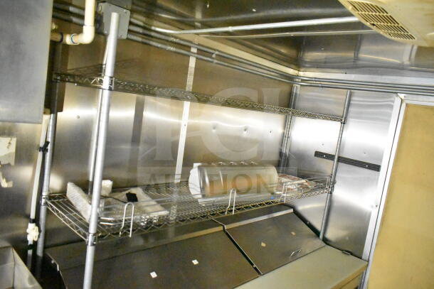 2021 Diamond Cargo 8.5'x24' food trailer interior with metal shelving, grease hood, and suppression system. Clean condition.