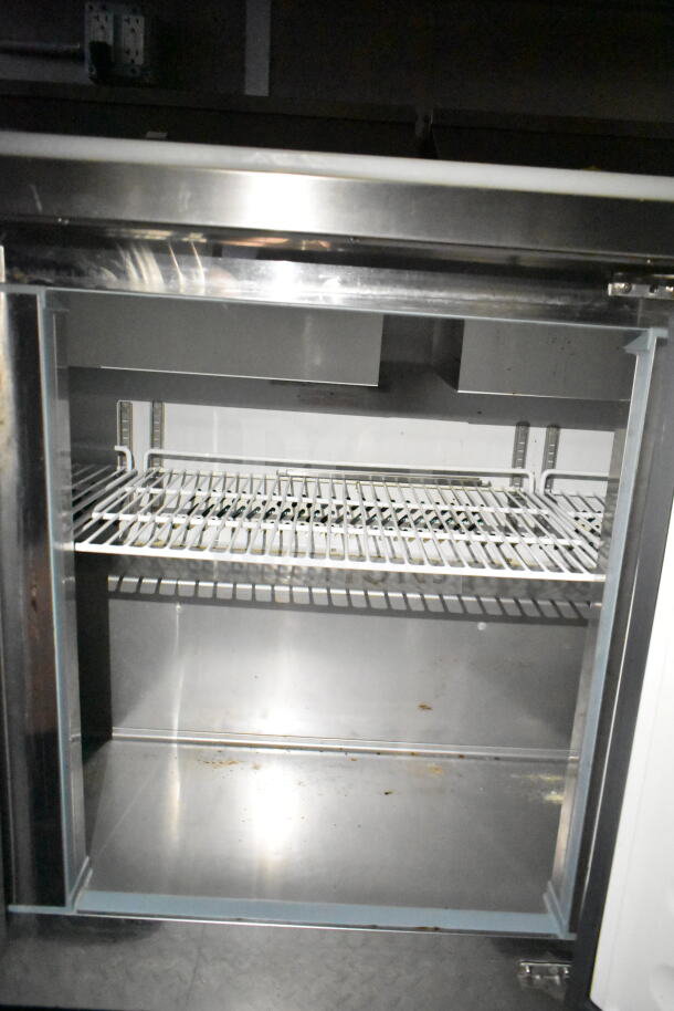 Interior view of a refrigeration unit inside a 2021 Diamond Cargo food trailer. Features wire shelving, stainless steel finish.
