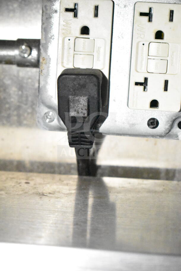 Power outlet with GFCI reset buttons inside 2021 Diamond Cargo food trailer, equipped with grease hood and Frymaster gas fryer.