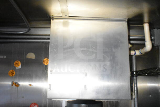 Industrial grease hood inside Diamond Cargo food trailer. Visible stickers read "USE FIRST." Stainless steel surface.