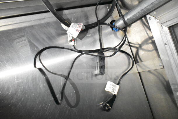 Electrical cords and power strip inside the 2021 Diamond Cargo 8.5'x24' food trailer. Tags display safety warnings.