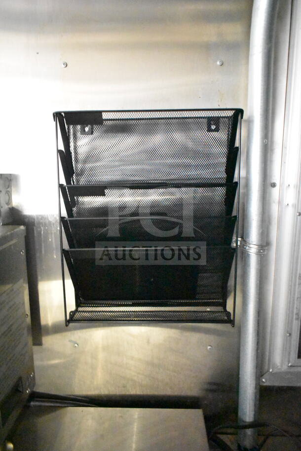 2021 Diamond Cargo food trailer interior showing metal wall and black wire rack, part of a well-equipped mobile kitchen.