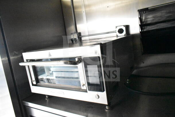 Stainless steel oven inside 2021 Diamond Cargo food trailer with visible grease hood and electrical outlets.