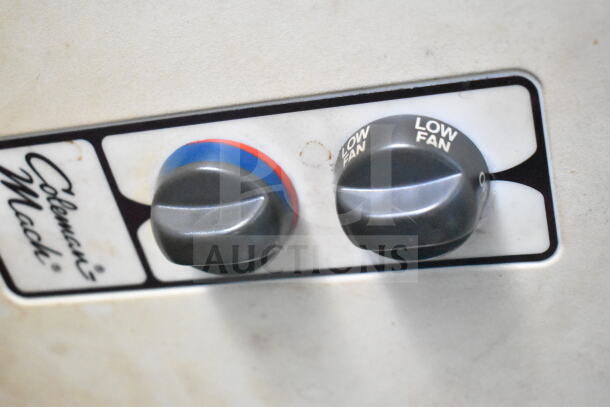 Coleman Mach control panel with temperature and fan settings, featuring dials labeled for low fan and a color-coded temperature indicator.