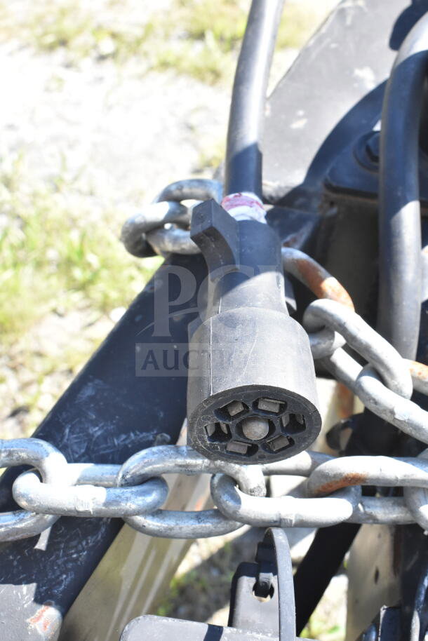 Close-up of the hitch connection on a 2021 Diamond Cargo 8.5'x24' food trailer, showing heavy-duty chains and wiring.