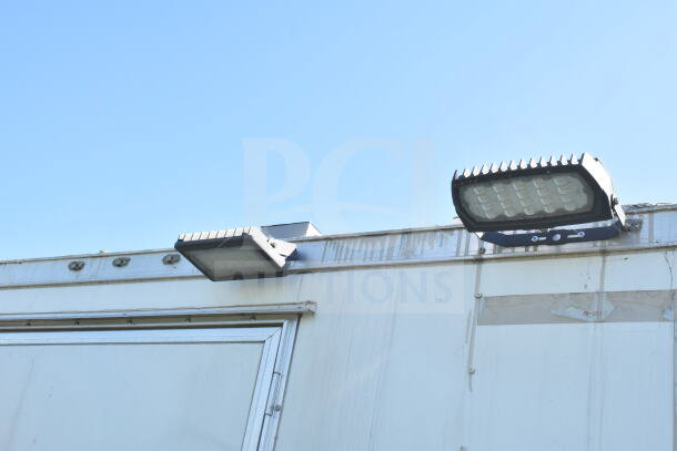 Exterior of 2021 Diamond Cargo 8.5'x24' food trailer with lighting fixtures and visible wear, VIN: 53NBE242XM1089713.