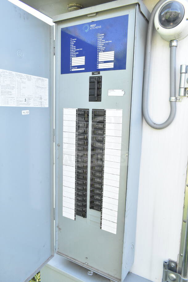 Electrical panel inside a 2021 Diamond Cargo food trailer. Features multiple circuit breakers, labeled "REEF Kitchens."