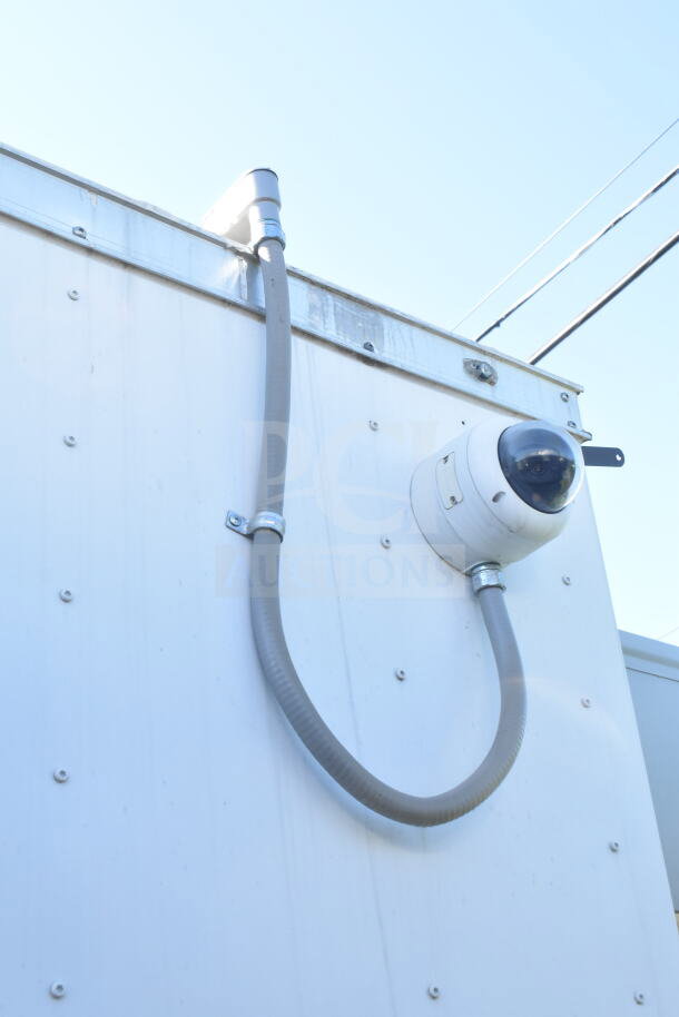 Diamond Cargo trailer exterior with a security camera and grey conduit cable attached.