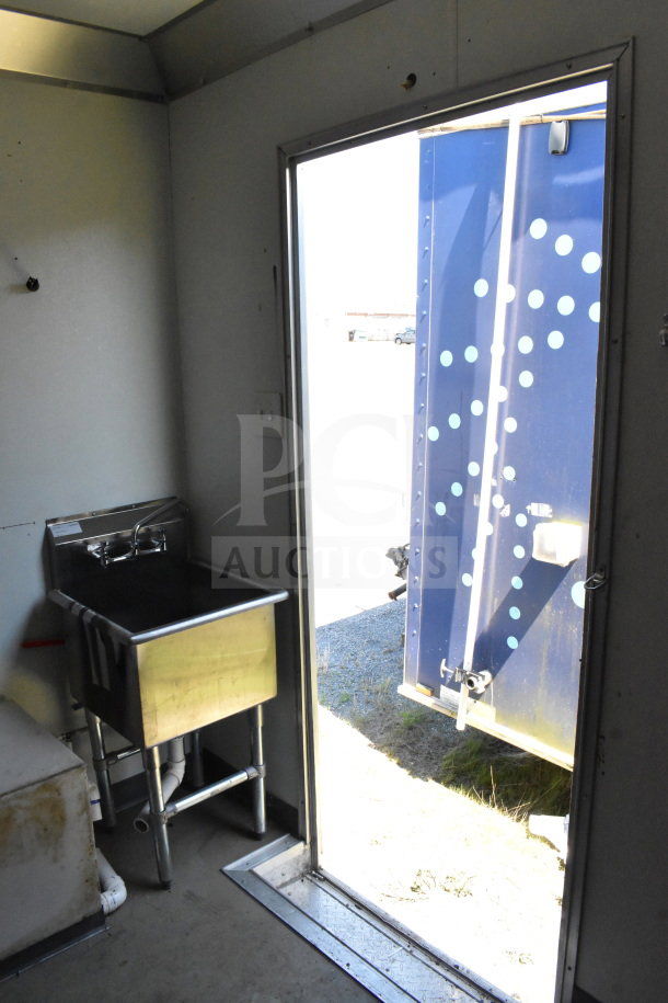 2021 Diamond Cargo 8.5'x24' Food Trailer interior with a stainless steel sink, open door showing blue exterior. VIN: 53NBE2424M1089867.