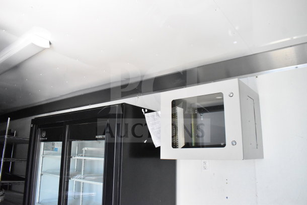 2021 Diamond Cargo 8.5'x24' food trailer interior, featuring refrigeration unit and wall-mounted equipment cabinet.
