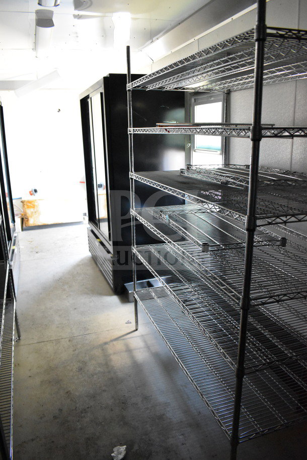 Interior of 2021 Diamond Cargo 8.5'x24' food trailer with metal shelving and storage space, in used condition.