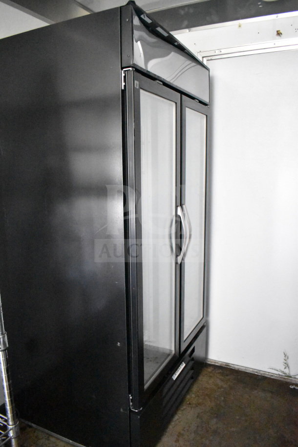 Double-door black commercial refrigerator inside 2021 Diamond Cargo 8.5'x24' food trailer, pristine condition.