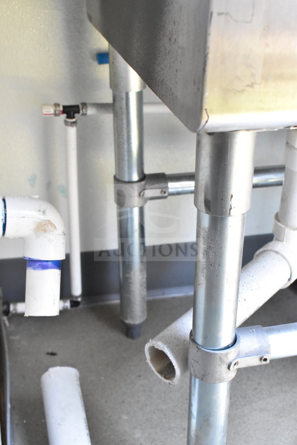 Close-up of piping and stainless steel fixtures in the 2021 Diamond Cargo 8.5'x24' food trailer, showing sturdy construction and condition.