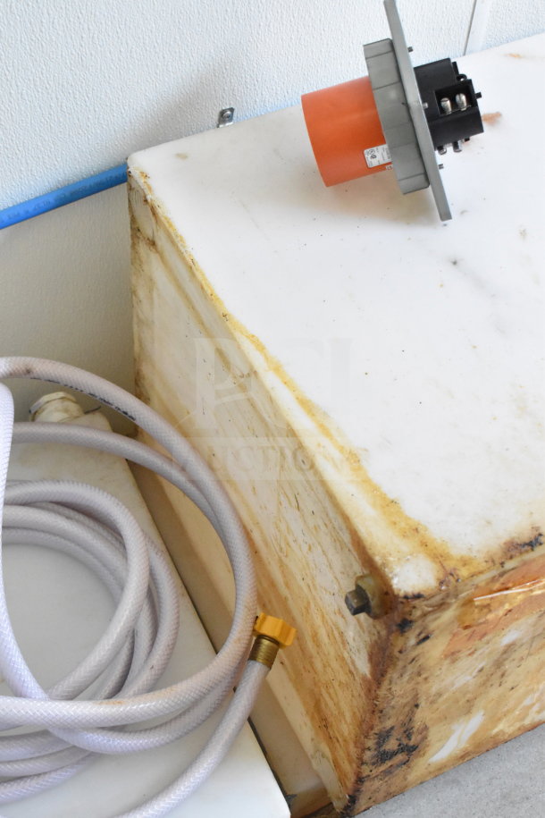 Close-up of a dirty plastic tank and hose in a 2021 Diamond Cargo 8.5'x24' food trailer, VIN 53NBE2424M1089867.